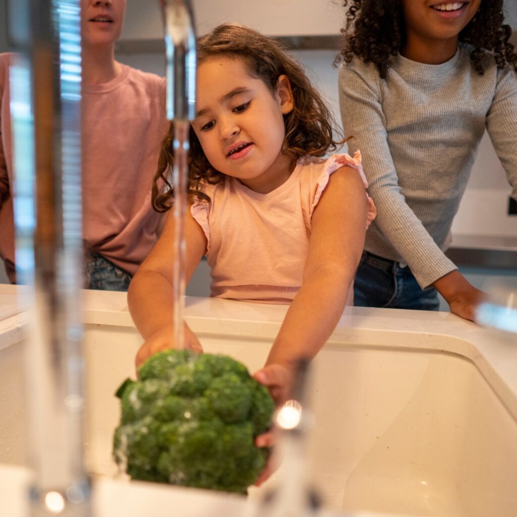 Kitchen sink faucet installation showing a modern faucet being fitted with new plumbing connections by Fateh Plumbing & Electric.