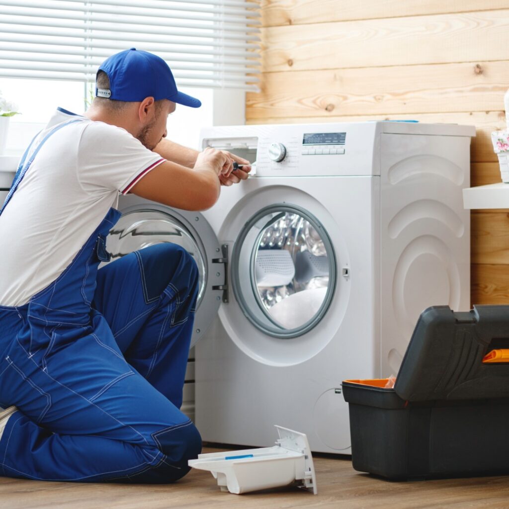 Washing machine repair service showing a technician inspecting the washer for leaks, drainage, and electrical issues.