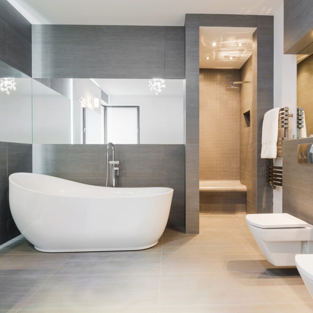 Renovated bathroom shower with new tiles, glass enclosure, and upgraded plumbing lines installed by Fateh Plumbing & Electric.